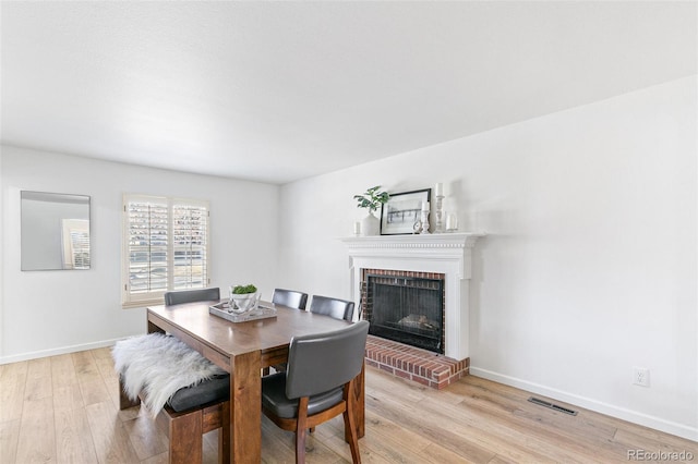 7193 S Newport Way, Centennial, CO 80112 - dining area with a fireplace and light wood-style flooring