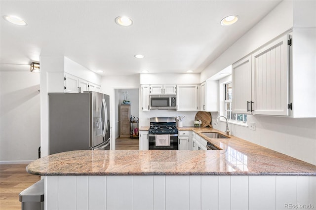 7193 S Newport Way, Centennial, CO 80112 - kitchen featuring stainless steel appliances, recessed lighting, light stone countertops, a peninsula, and light wood-style floors