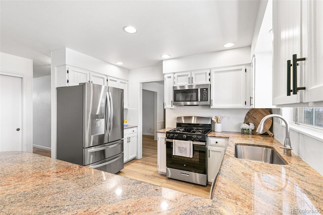 7193 S Newport Way, Centennial, CO 80112 - kitchen with stainless steel appliances, light stone countertops, recessed lighting, white cabinetry, and light wood-style flooring