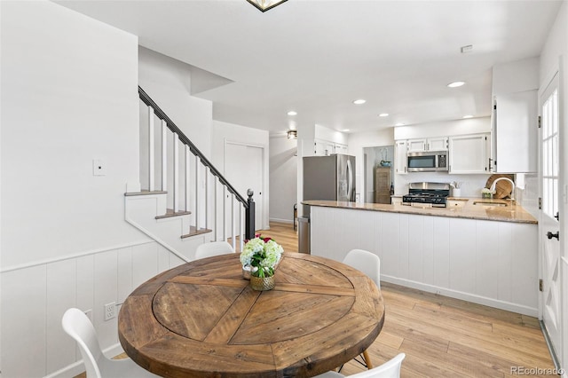 7193 S Newport Way, Centennial, CO 80112 - dining area with light wood-style floors, stairs, wainscoting, and recessed lighting