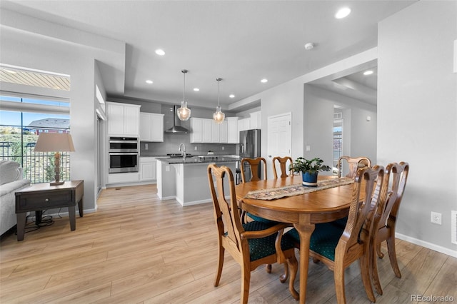 dining space with sink and light hardwood / wood-style floors