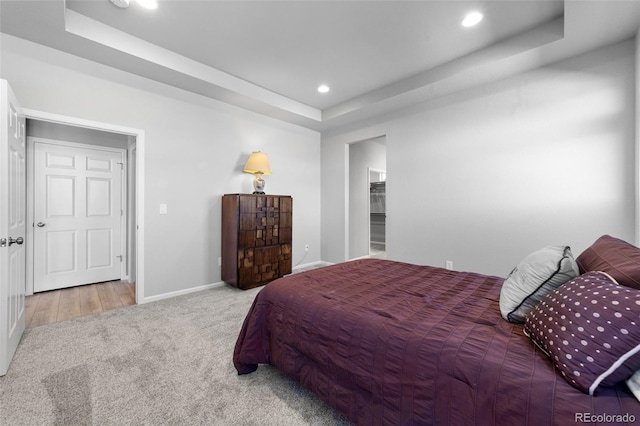 carpeted bedroom featuring a raised ceiling