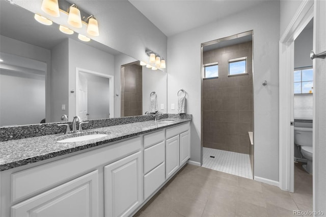 bathroom with vanity, toilet, a healthy amount of sunlight, and tile patterned floors