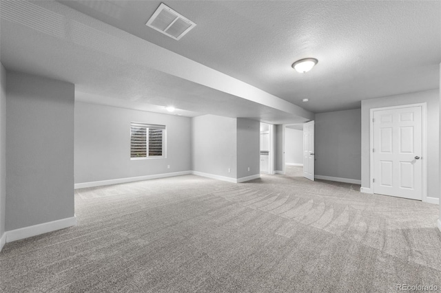 basement featuring a textured ceiling and light colored carpet