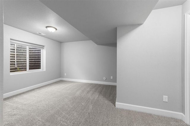 carpeted spare room featuring a textured ceiling