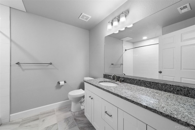 bathroom featuring vanity, toilet, and tiled shower