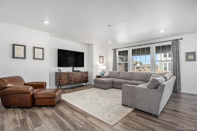 living room with a textured ceiling and dark hardwood / wood-style flooring