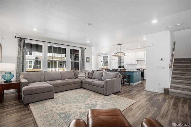 living room featuring dark wood-type flooring and a textured ceiling