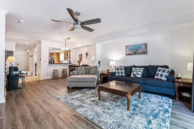 7250 Eastmoor Dr Unit 122, Denver, CO 80237 - living area with wood finished floors, ceiling fan, a chandelier, ornamental molding, and baseboards