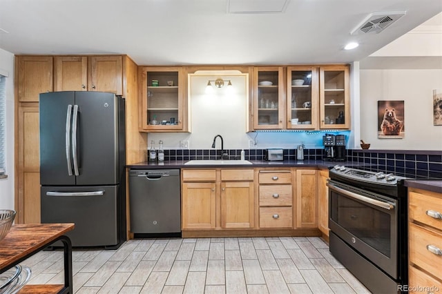 7250 Eastmoor Dr Unit 122, Denver, CO 80237 - kitchen with appliances with stainless steel finishes, a sink, dark countertops, wood tiled floors, and glass insert cabinets