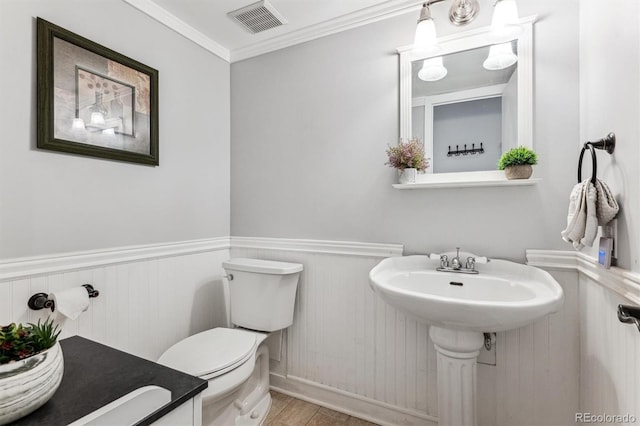 7250 Eastmoor Dr Unit 122, Denver, CO 80237 - half bath featuring toilet, a wainscoted wall, wood finished floors, and crown molding