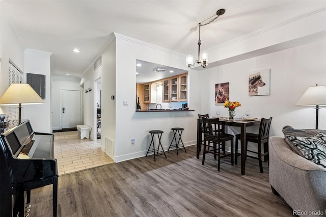 7250 Eastmoor Dr Unit 122, Denver, CO 80237 - dining area with a chandelier, crown molding, wood finished floors, electric panel, and recessed lighting