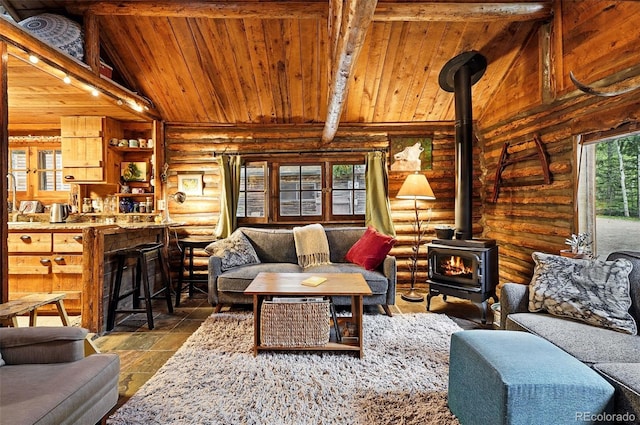 1634 Caribou Rd, Nederland, CO 80466 - living area with a wood stove, log walls, and wooden ceiling
