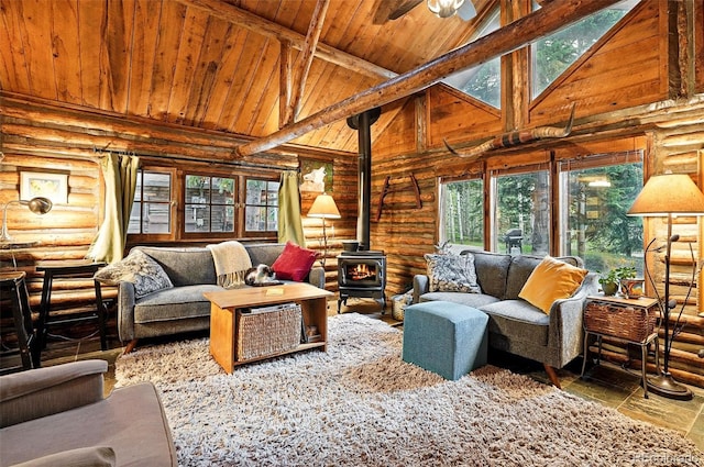 1634 Caribou Rd, Nederland, CO 80466 - living area featuring a wood stove, a wood ceiling with exposed beams, log walls, healthy amount of natural light, and high vaulted ceiling