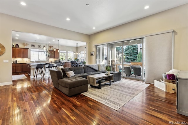 living area with dark wood-style floors, recessed lighting, and baseboards