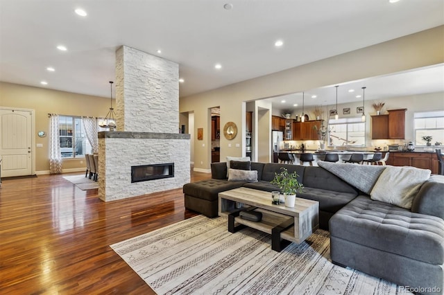 living area with recessed lighting, baseboards, dark wood-style floors, and a fireplace