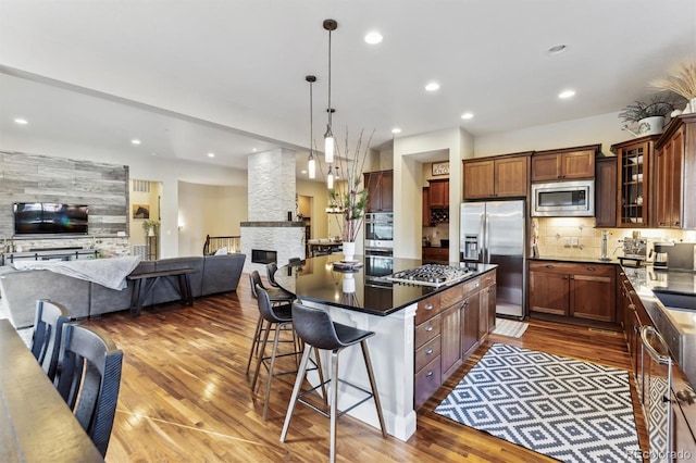 kitchen with open floor plan, appliances with stainless steel finishes, and wood finished floors