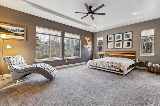 carpeted bedroom with a ceiling fan, a raised ceiling, recessed lighting, and baseboards