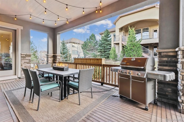 wooden terrace featuring area for grilling and outdoor dining area