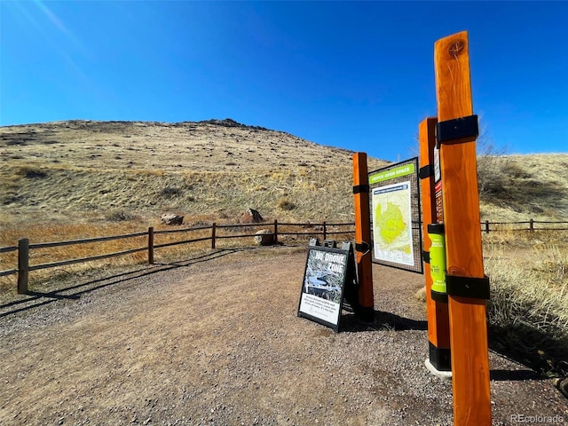 view of play area featuring a rural view, a mountain view, and fence