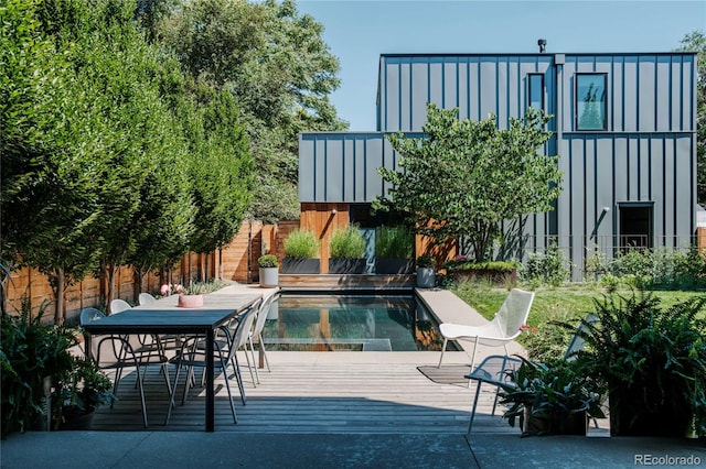 view of swimming pool featuring a deck and fence