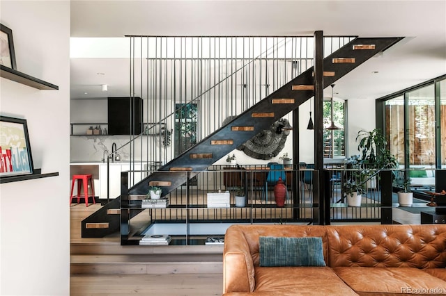 stairway featuring floor to ceiling windows and wood finished floors