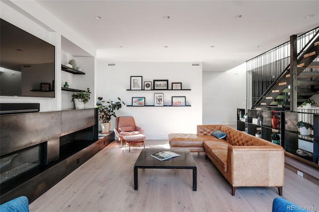 living room with stairway and wood finished floors