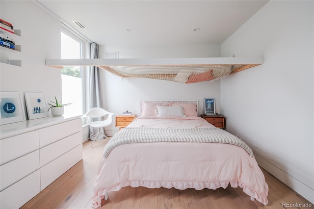 bedroom featuring visible vents and light wood finished floors