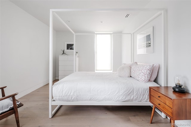 bedroom featuring visible vents, baseboards, and light wood-style floors