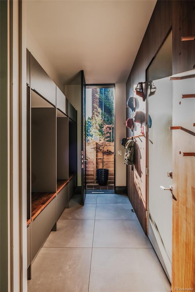 hall with floor to ceiling windows and concrete flooring