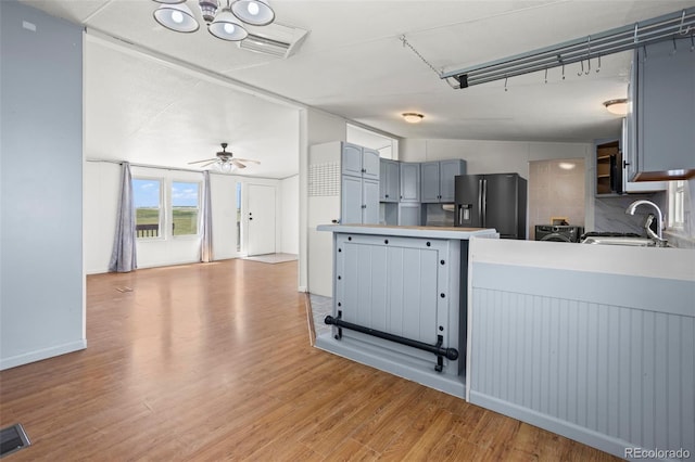 7855 Edison Rd, Yoder, CO 80864 - kitchen with fridge with ice dispenser, light wood-style flooring, a peninsula, gray cabinetry, and light countertops