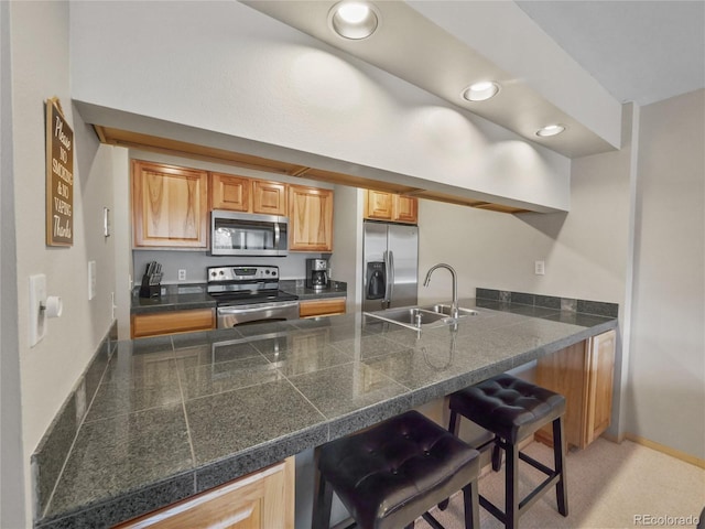 kitchen featuring sink, stainless steel appliances, and a kitchen bar