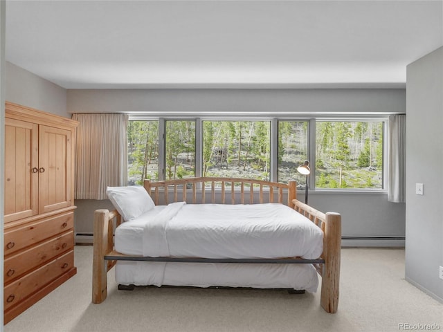 bedroom with light carpet and baseboard heating