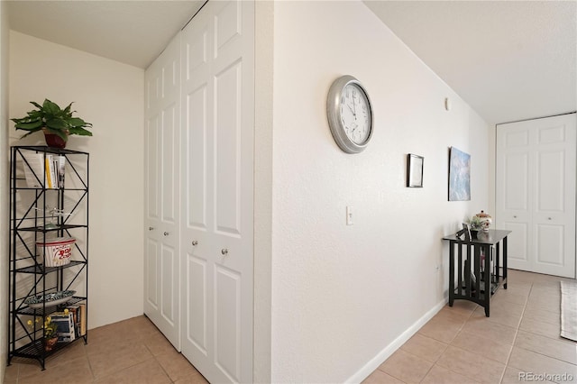 hallway featuring light tile patterned flooring and baseboards