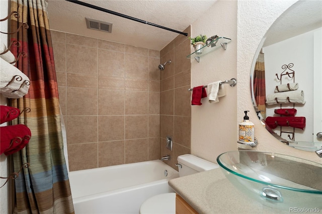 bathroom featuring vanity, visible vents, shower / tub combo, a textured ceiling, and toilet