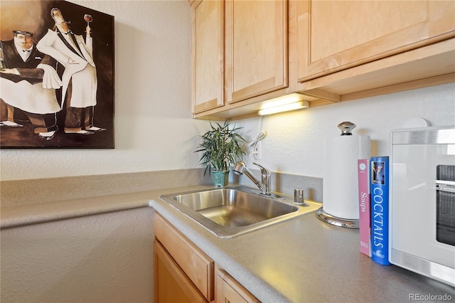 kitchen featuring a sink, light brown cabinetry, and light countertops