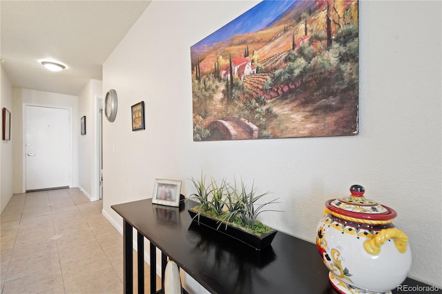 hallway featuring tile patterned floors and baseboards