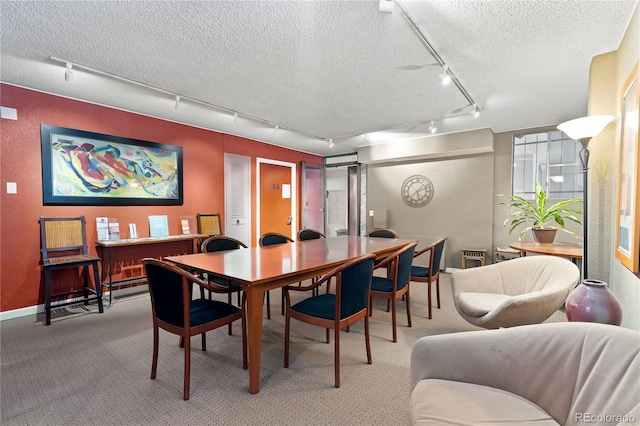 dining area with baseboards, light colored carpet, and a textured ceiling