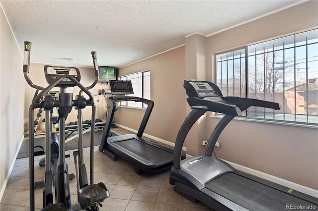 workout area with baseboards, a textured ceiling, and crown molding