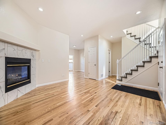 unfurnished living room with a fireplace and light hardwood / wood-style floors