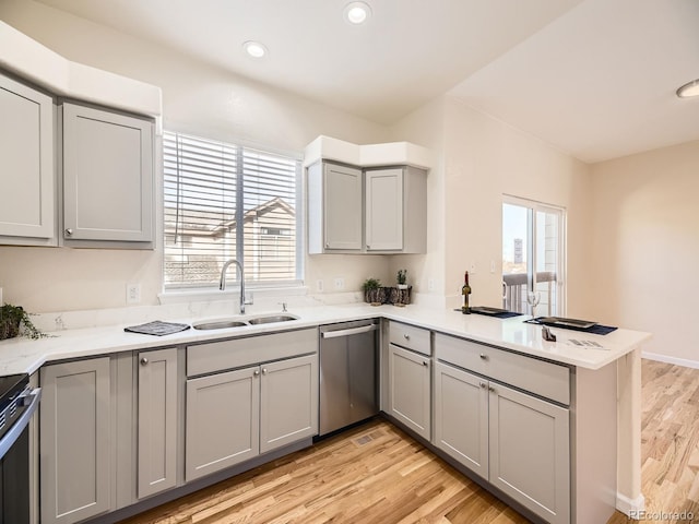 kitchen featuring stainless steel appliances, a wealth of natural light, sink, and kitchen peninsula