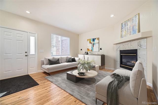 living room with hardwood / wood-style flooring and a high end fireplace