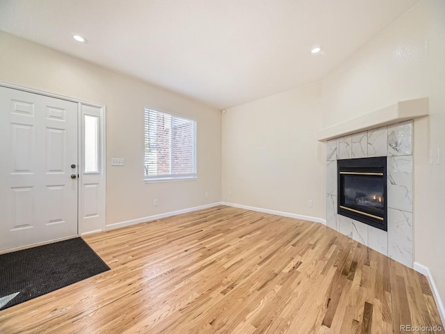 foyer with light hardwood / wood-style floors and a tile fireplace