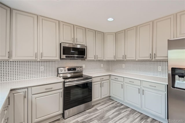 kitchen with tasteful backsplash, light hardwood / wood-style flooring, and stainless steel appliances