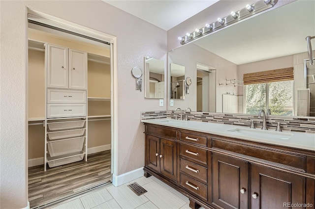 bathroom with vanity, backsplash, and hardwood / wood-style flooring