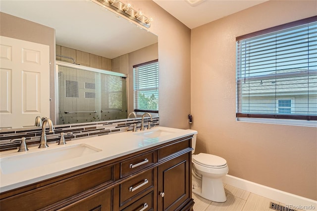 bathroom featuring toilet, tasteful backsplash, an enclosed shower, tile patterned flooring, and vanity