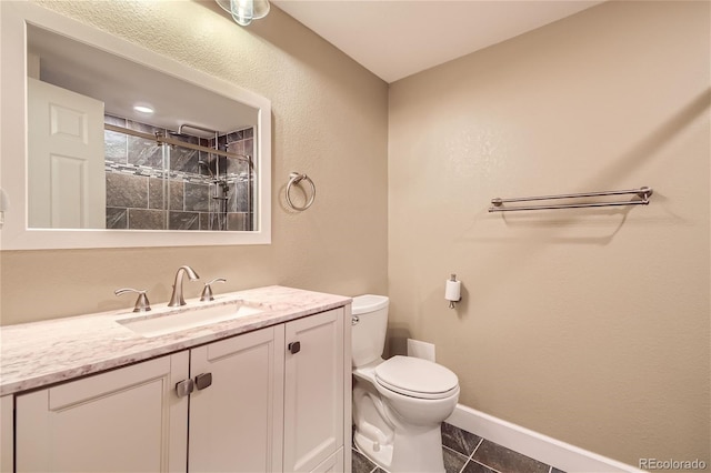 bathroom featuring tiled shower, toilet, tile patterned flooring, and vanity