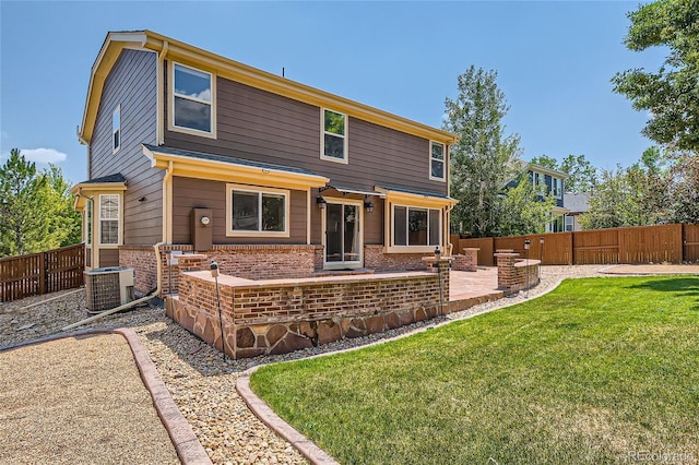 rear view of property with a patio area, a lawn, and central AC