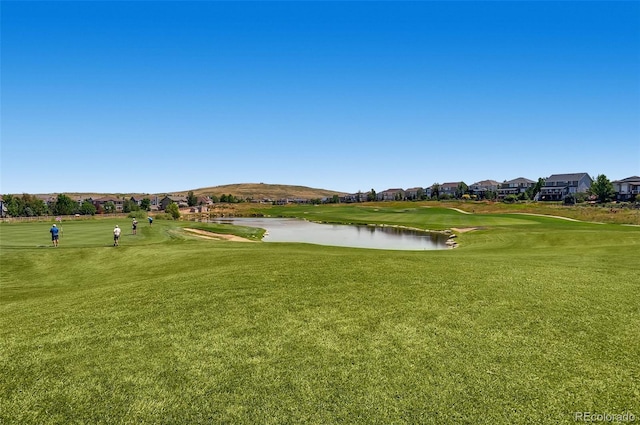 view of property's community with a yard and a water and mountain view