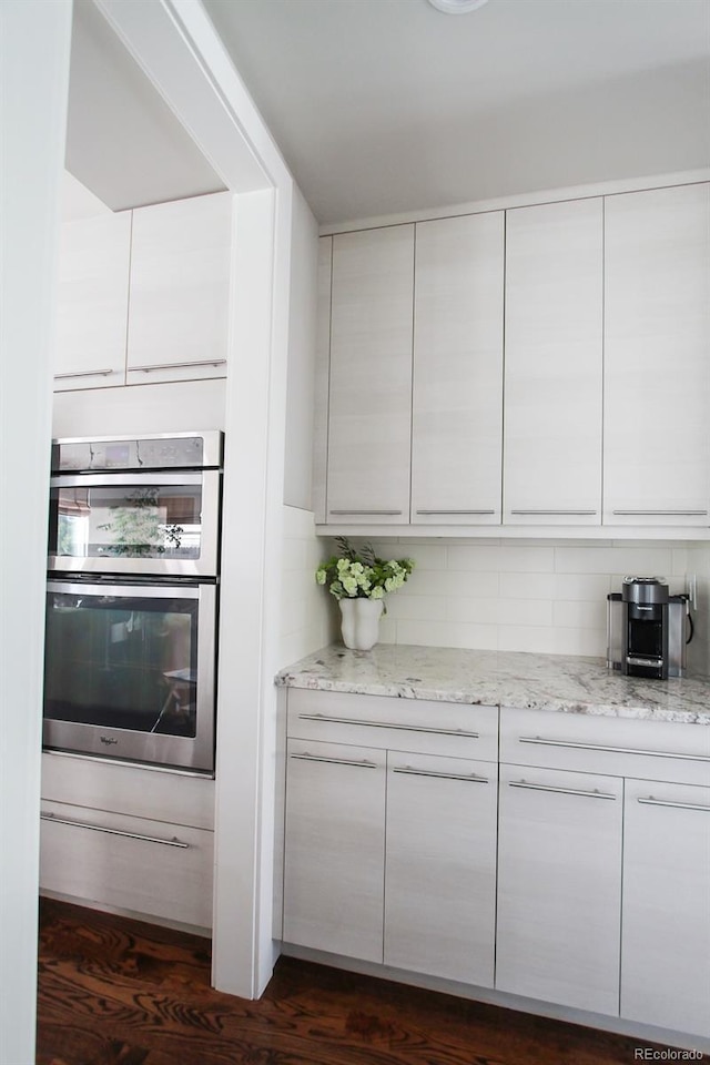 kitchen featuring white cabinetry, light stone counters, modern cabinets, and tasteful backsplash